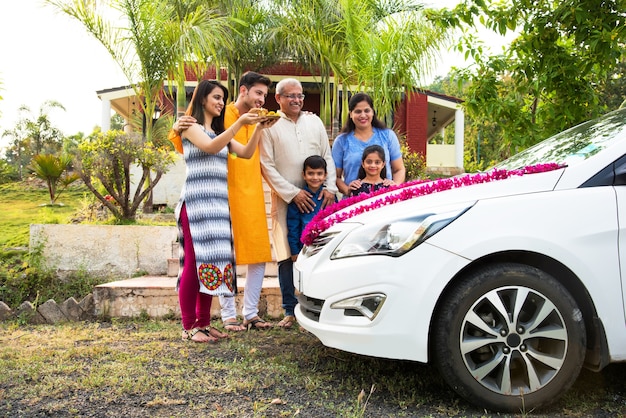 Indian Modern parents with kids welcoming new ca traditionally, performing Pooja