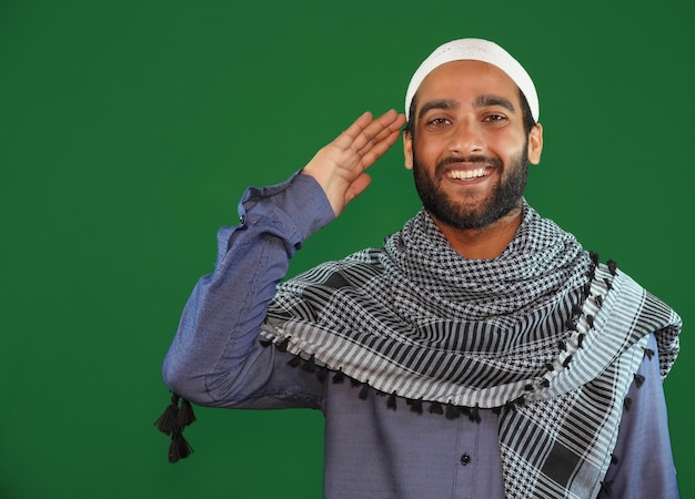 Photo indian muslim boy saluting on green screen background