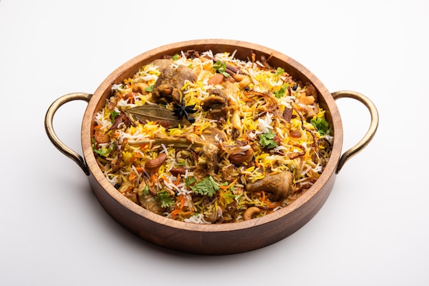 Indian Mutton biryani prepared in Basmati Rice served with Yogurt dip over moody background, Selective focus