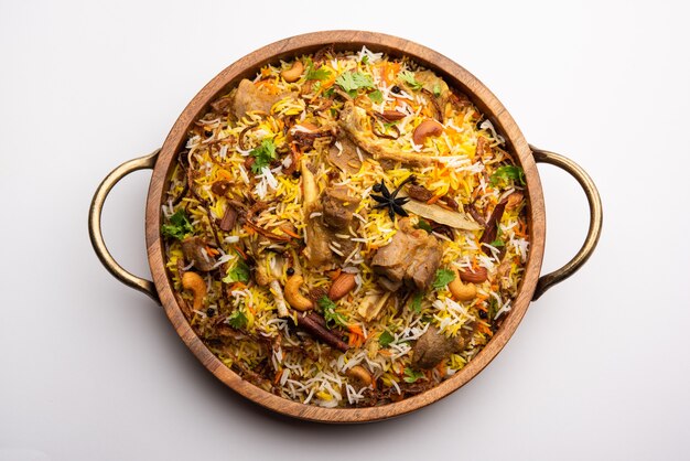 Indian Mutton biryani prepared in Basmati Rice served with Yogurt dip over moody background, Selective focus