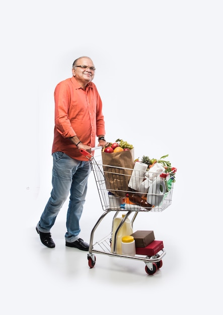 Indian old man with shopping cart or trolly full of vegetables, fruits and groceries