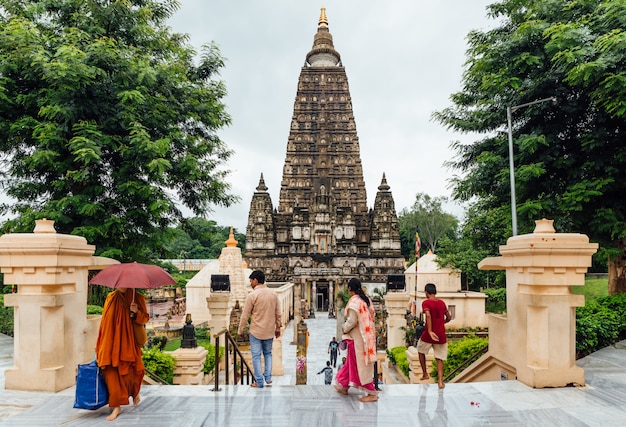 Bodh Gaya, Bihar, India에서 비가 오는 동안기도와 순례자를 위해 Mahabodhi Temple에 맨발로 걷는 인도 사람들