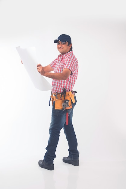 Indian plumber holding drawing roll and Pipe wrench or plumbing spanner or smartphone, standing isolated