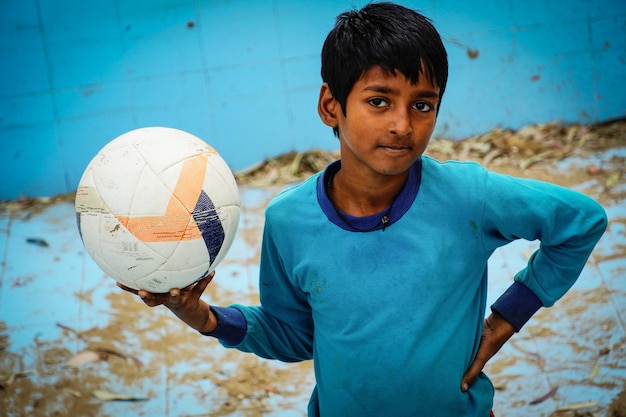 Indian poor kid with football outdoor image hd