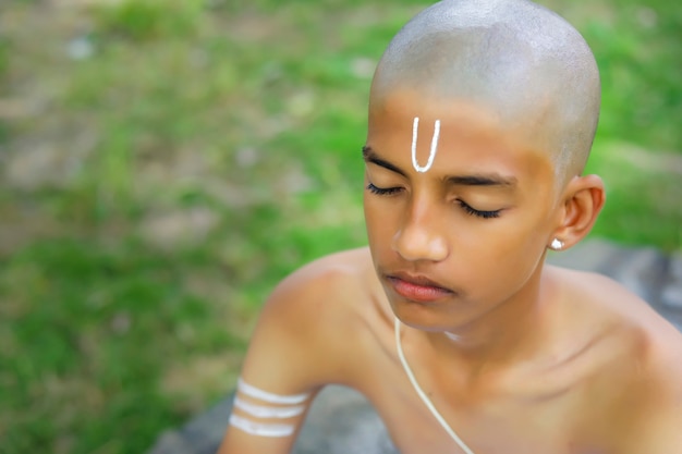 The indian priest child doing meditation