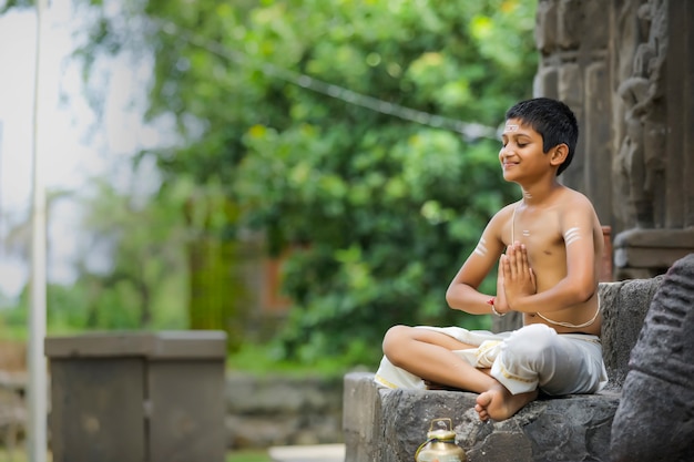 Indian priest child doing yoga at park