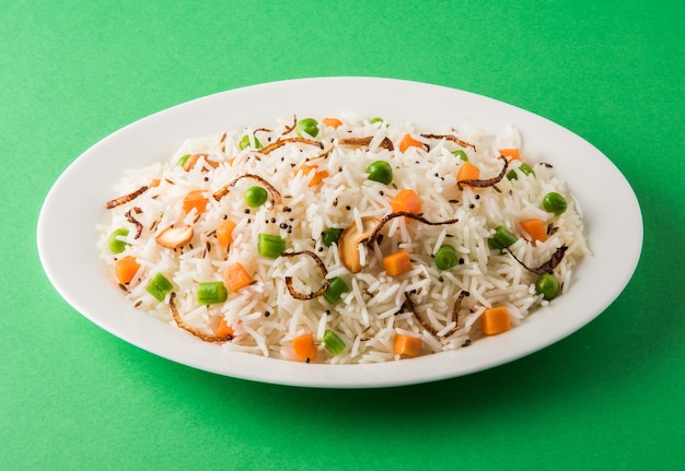 Indian Pulav or veg biryani made using Basmati Rice served in a white ceramic plate, selective focus