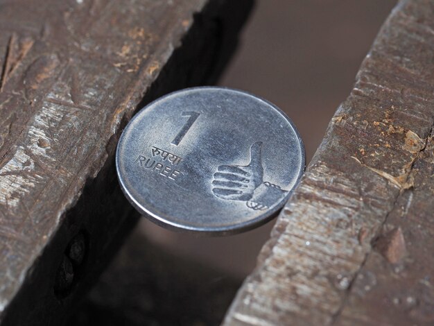 금속 그립에 고정된 인도 루피 동전. 재정 문제의 개념입니다.