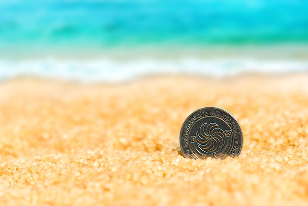 indian rupee in the sand on the background of beach and sea