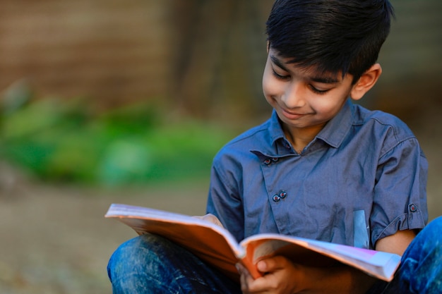 Индийский сельский ребенок читает книгу
