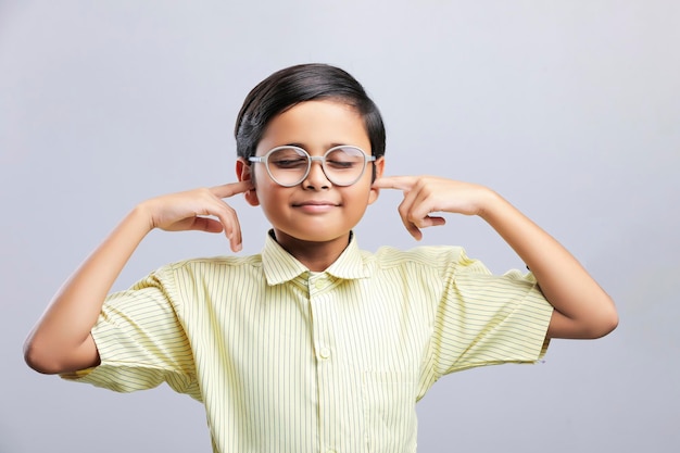 Indian school boy finger in ear and giving cant hearing gesture