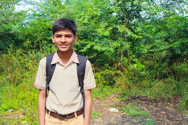 Indian school boy standing over nature background