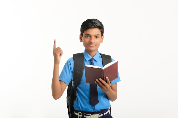 Indian school boy in uniform and reading diary on white background
