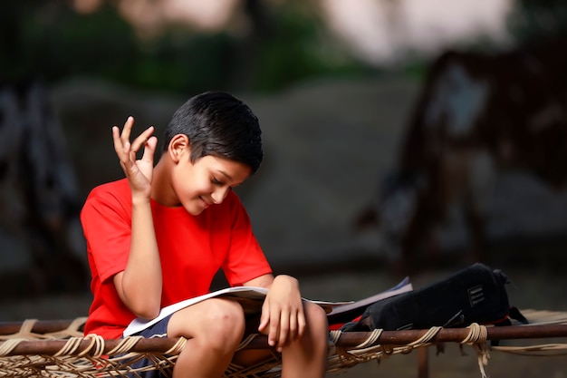 Photo indian school boy with note book and studying at home