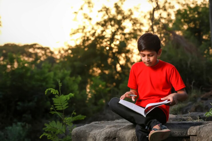 फोटो indian school boy with note book and studying at home