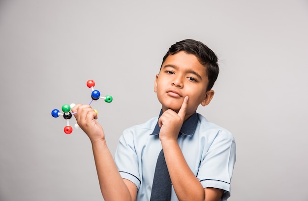 Indian school kid or science student Using Molecular Model Kit for studying physics, selective focus