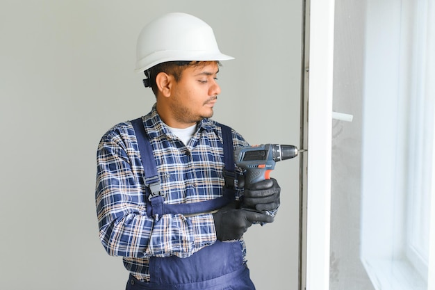 indian service man installing window with screwdriver