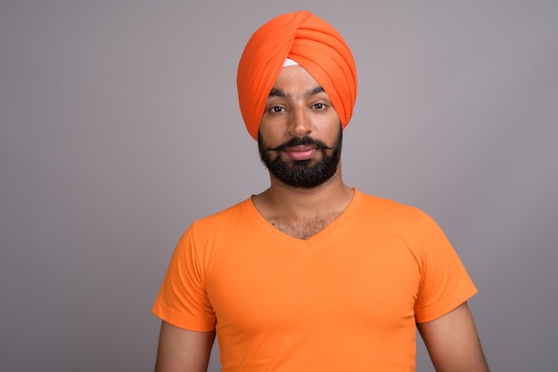 Indian Sikh man wearing turban and orange shirt