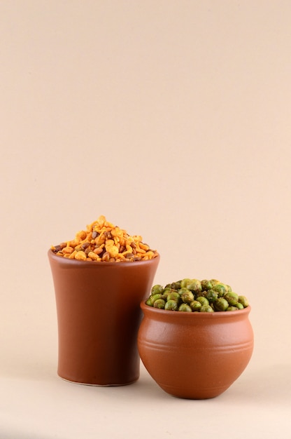 Indian snack: Mixture and Spiced fried green peas {chatpata matar} in clay pots.