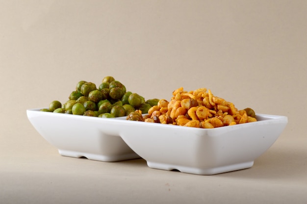 Indian snack: Mixture and Spiced fried green peas {chatpata matar} in white plate.