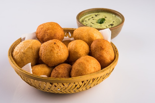 인도 간식 Aloo Bonda 또는 batata vada 또는 urad daal vada 또는 pakoda 또는 pakora. 녹색 처트니와 함께 제공됩니다. 선택적 초점