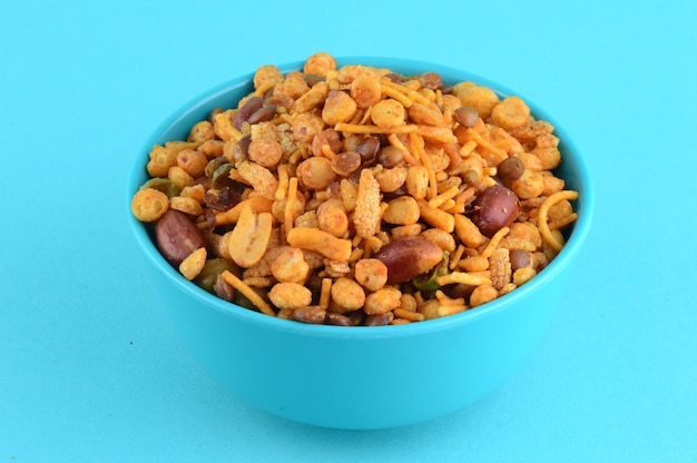 Spuntini indiani: miscela (noci tostate con masala sale pepe, legumi, channa masala dal piselli verdi) nella ciotola blu in