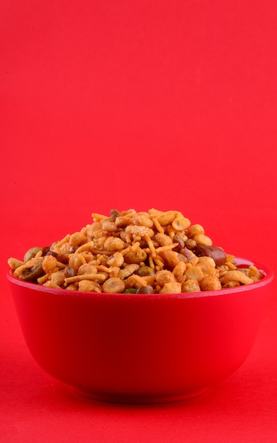 Indian Snacks : Mixture (roasted nuts with salt pepper masala, pulses, channa masala dal, green peas) in red bowl