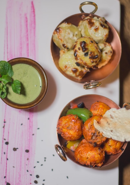 Indian snacks served with green chutney top view.