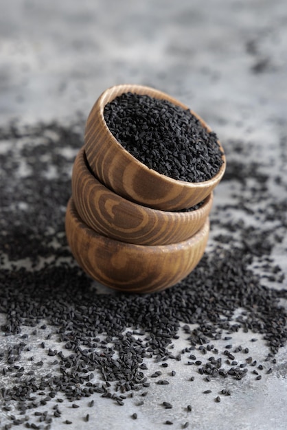 Indian spice Black cumin nigella sativa or kalonji seeds in wooden bowls close up