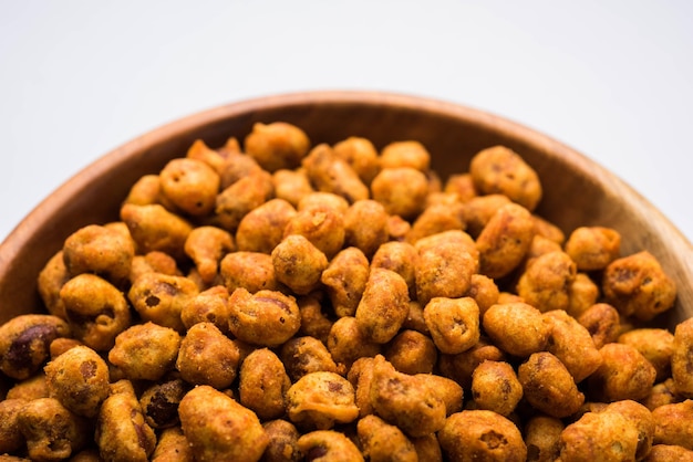 Indian Spiced coated fried and crunchy Masala Peanut. Popular Namkeen snack. served in plate of bowl. selective focus