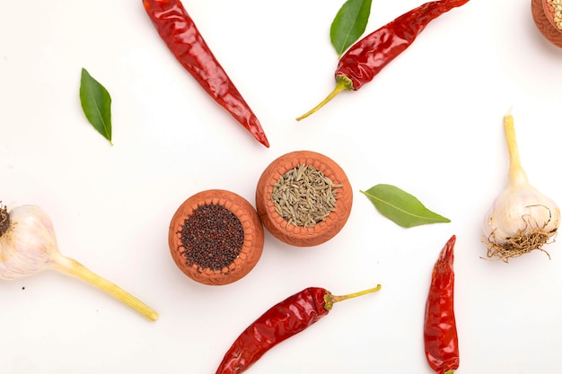 Indian spices and herbs on white surface.