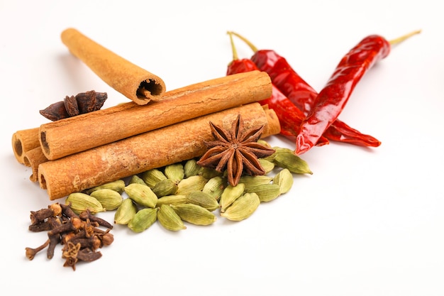 Indian spices and herbs on white surface.