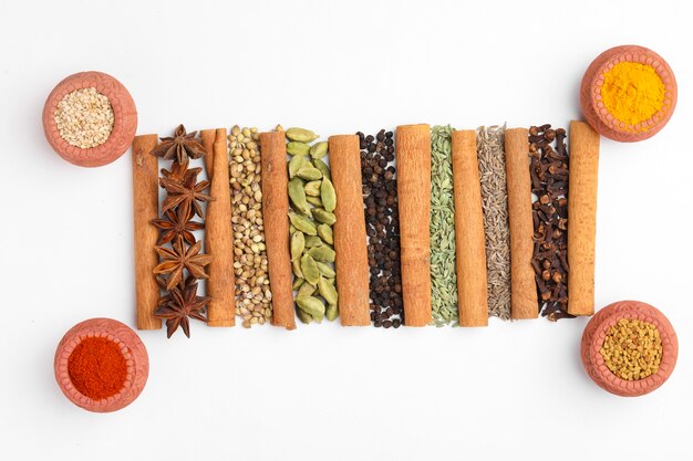 Indian spices and herbs on white surface.