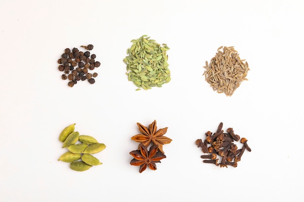 Indian spices and herbs on white surface.