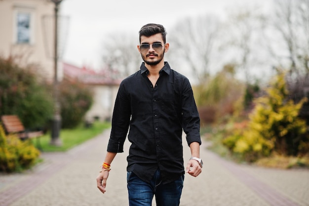 Indian stylish man at black shirt and sunglasses posed outdoor