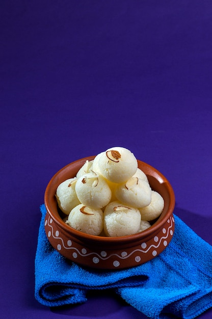 Dolce o dessert indiano - rasgulla, famoso dolce bengalese in ciotola di argilla con tovagliolo blu