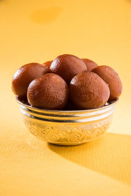 丸いセラミックボウルで提供されるインドの甘い食べ物グラブジャムン