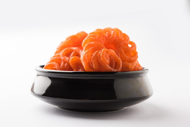 Photo indian sweet imarti or jalebi served in white ceramic plate over white background