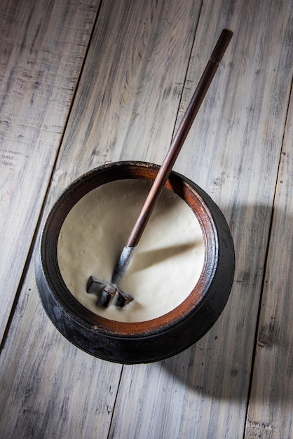 Indian sweet Lassi made up of milk, curd, sugar and salt mixed with ice cubes, served in a jumbo steel glass, prepared in traditional earthen pot