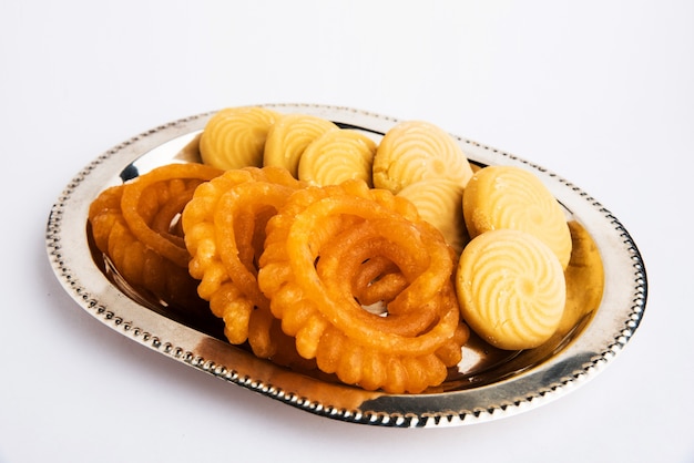 Indian sweet pedha, jalebi, motichoor or bundi laddu and  burfi in a silver plate isolated on white surface