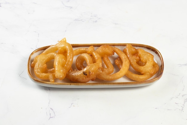 Indian sweets deep fired jalebi jilipi jilabi served in a dish isolated on background top view