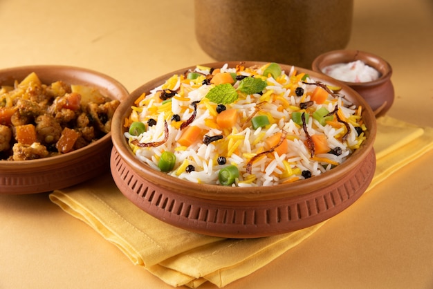 Indian Tasty vegetable pulav or veg biryani made using basmati rice and served in a terracotta or ceramic bowl