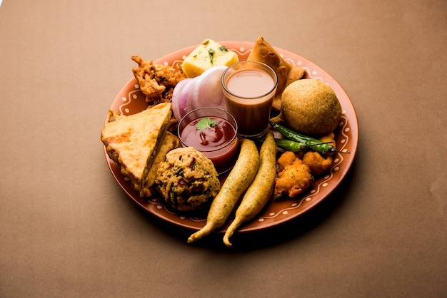 Gli snack indiani dell'ora del tè in gruppo includono veg samosa, kachori, kachaudi, aloo bonda, khaman dhokla, pane, cipolla, peperoncino e moong pakora, pakoda, bhaji, bhajji, bhajiya, bajji con salse