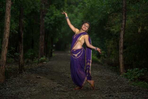 Индийский традиционный красивая молодая девушка в сари позирует на открытом воздухе