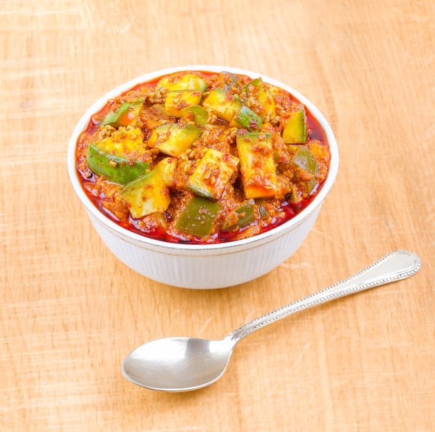 Indian Traditional Raw Mango Pickle on Wooden Background