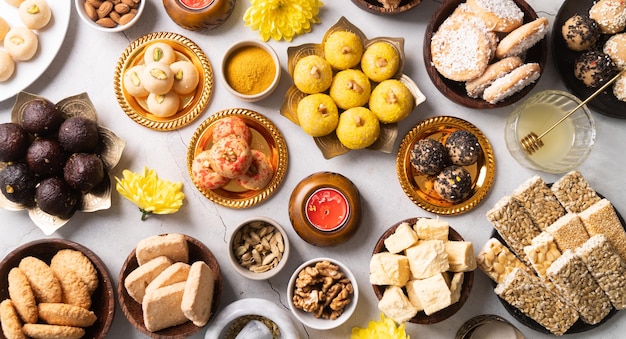 Dolci tradizionali indiani laddu gulab jamun soan papdi burfi per il festival su sfondo rosso con spazio di copia laici piatta