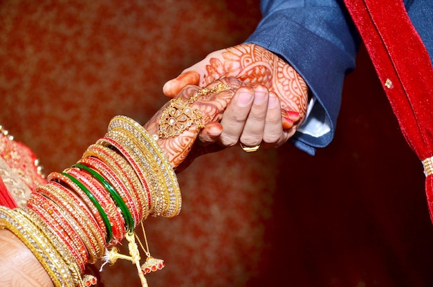 写真 インドの伝統的な結婚式のカップルが一緒に瞬間を手渡します