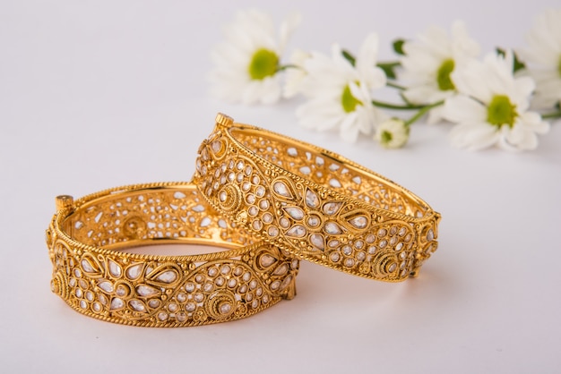 Indian traditional wedding jewellery, bangles with huldi kumkum and white flowers. selective focus