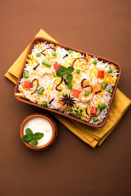 Indian Vegetable Pulav or Biryani made using Basmati Rice, served in terracotta bowl. selective focus