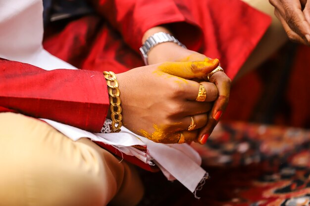 Fotografia di matrimonio indiano, mani dello sposo cerimonia haldi